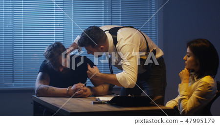 Violent policeman interrogating criminal about drugs 47995179