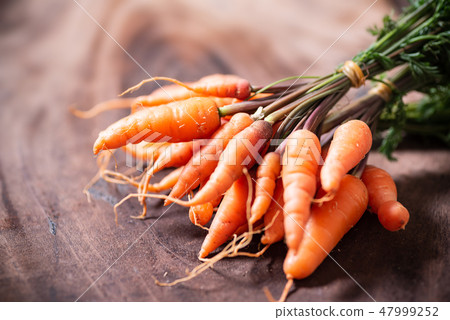Fresh carrots on wooden background Fresh carrots on wooden background 47999252
