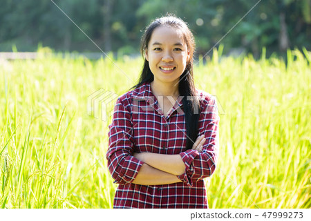 Asian woman farmer in organic rice field 47999273