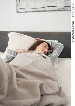 A woman sleeping in bed 47999338