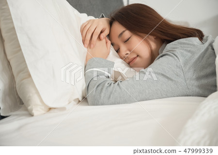 A woman sleeping in bed 47999339