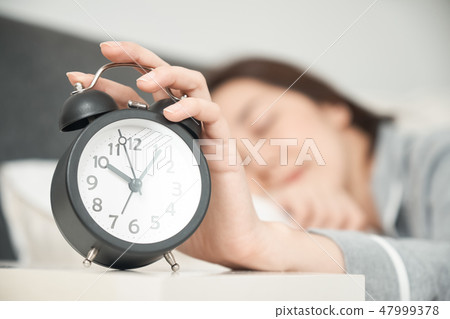 A waking woman in bed 47999378