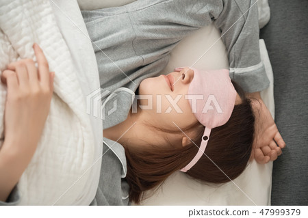 A woman sleeping in bed 47999379