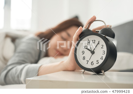 A waking woman in bed 47999428