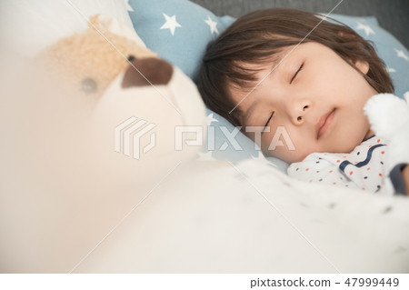 Child sleeping in bed Child sleeping in bed 47999449