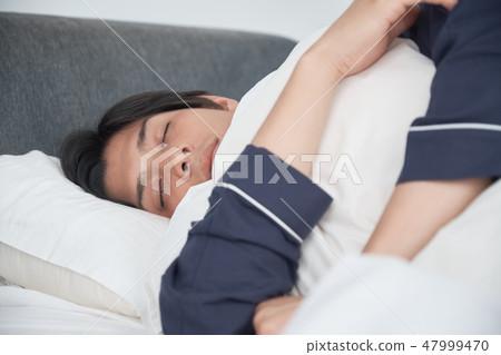 A man sleeping in bed A man sleeping in bed 47999470