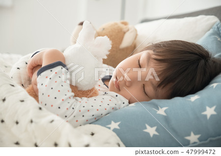 Child sleeping in bed Child sleeping in bed 47999472