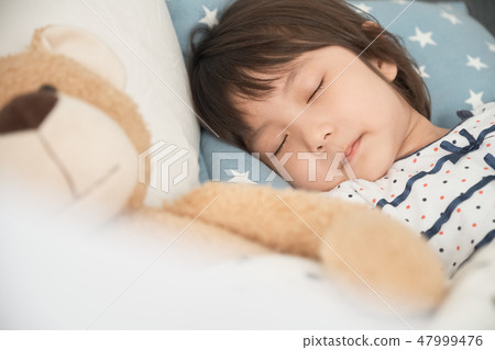 Child sleeping in bed Child sleeping in bed 47999476