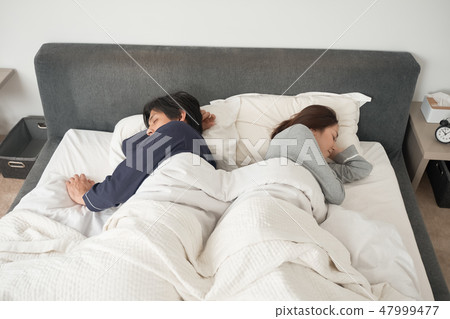 A couple sleeping in bed A couple sleeping in bed 47999477