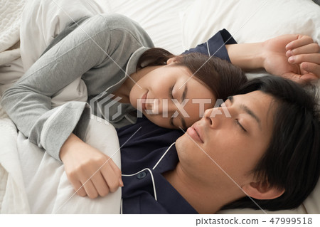 A couple sleeping in bed 47999518