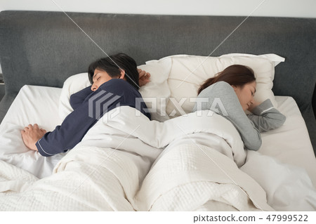 A couple sleeping in bed 47999522