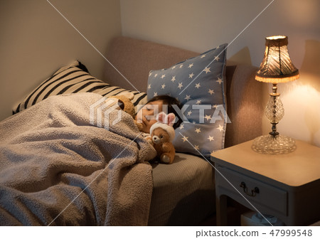 Child sleeping in bed 47999548