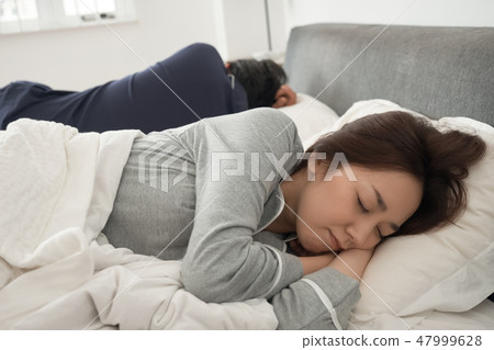 A couple sleeping in bed A couple sleeping in bed 47999628