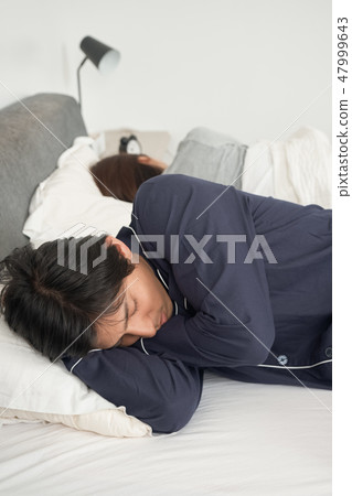 A couple sleeping in bed 47999643