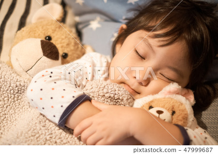 Child sleeping in bed Child sleeping in bed 47999687