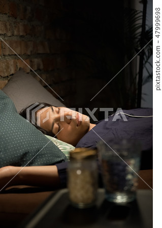 A man sleeping in bed A man sleeping in bed 47999698