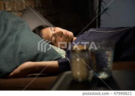 A man sleeping in bed A man sleeping in bed 47999821