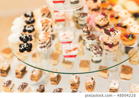 Delicious sweets on wedding candy buffet with desserts, cupcakes 48004228