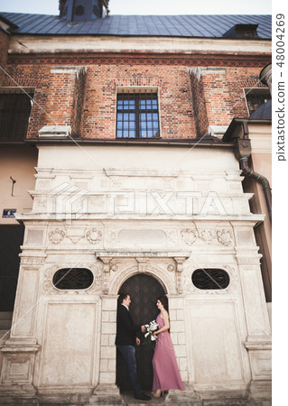 Elegant beautiful wedding couple posing near a church. Krakow 48004269