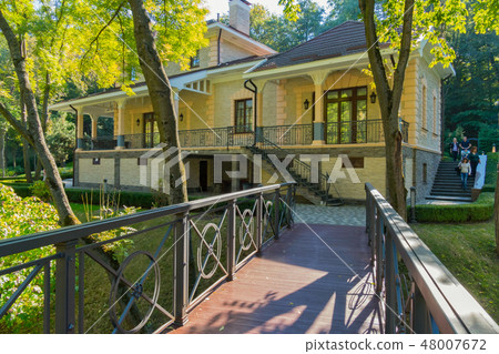 A wooden bridge leading to the house with a stairc 48007672
