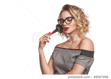Portrait of female stylist standing with makeup brushes Portrait of female stylist standing with makeup brushes 48007806