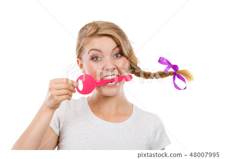 Teenage girl with braid biting key Teenage girl with braid biting key 48007995