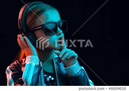 Young girl with headphones enjoying music 48009016