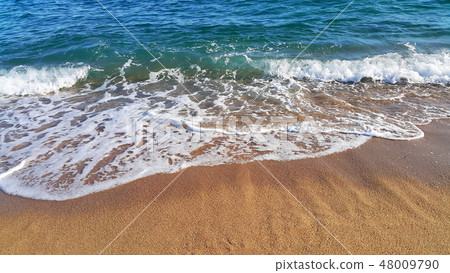 Sea wave with white foam in the coastal sand Sea wave with white foam in the coastal sand 48009790