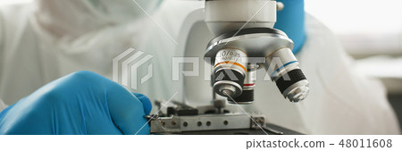 Male chemist in blue protective gloves look Male chemist in blue protective gloves look 48011608