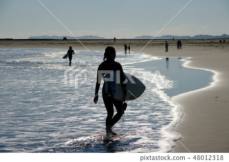 Rear view of female surfer 48012318