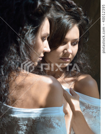Sexy woman looking to the mirror at the window. Sexy woman looking to the mirror at the window. 48012395