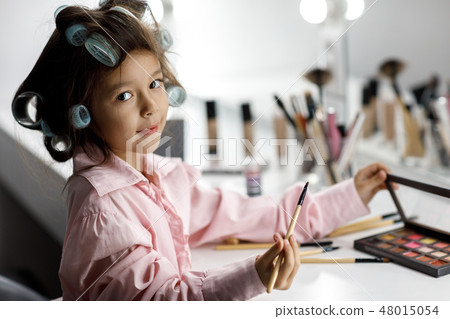 Cute little girl playing with her mother's cosmetic Cute little girl playing with her mother's cosmetic 48015054