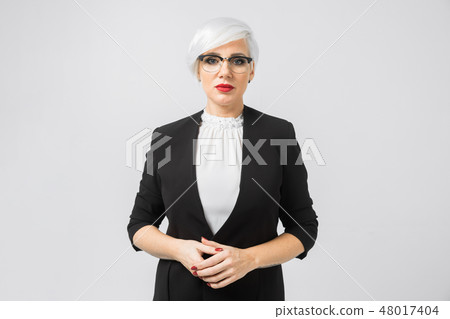 Portrait of a confident business lady in a strict suit isolated on a light background Portrait of a confident business lady in a strict suit isolated on a light background 48017404