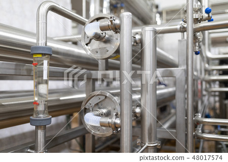 Steel pipelines and cables in factory interior as industrial zone background concept Steel pipelines and cables in factory interior as industrial zone background concept 48017574