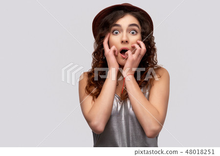 Surprised European woman keeps hands on cheeks 48018251