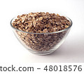 oat flakes in a glass bowl on white backrgound 48018576
