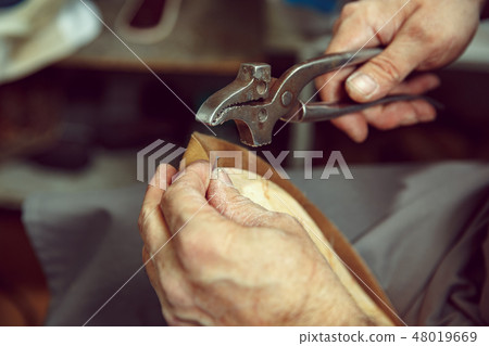 Enjoying process of creation custom made shoes. Workplace of shoe designer 48019669