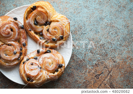 Fresh buns with raisins and icing. 48020082