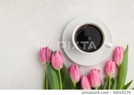 Black coffee in white Cup and tulips. Black coffee in white Cup and tulips. 48020176