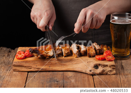 The chef cuts knife ready to eat pork ribs. The chef cuts knife ready to eat pork ribs. 48020533