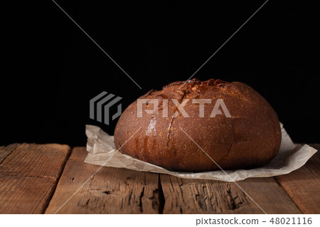 Tasty rustic bread on wooden table. 48021116