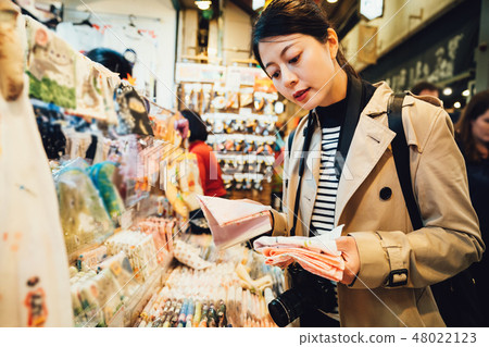 woman buying souvenirs in handkerchief vendor 48022123