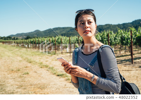 Asian woman in a vineyard with smiling cellphone 48022352