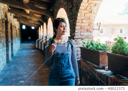 female walking along the corridor in old castle 48022372