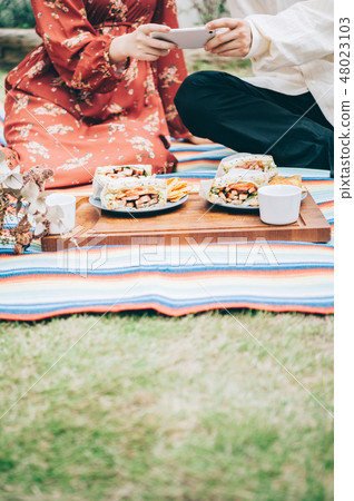 Men and women handling picnics in the garden 48023103