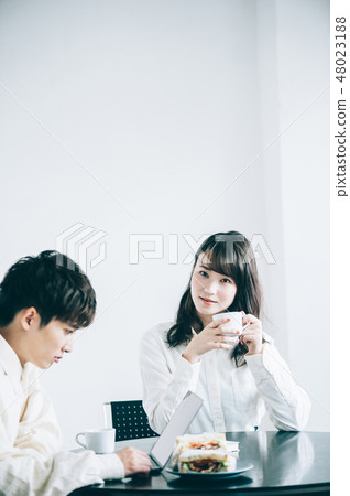 A man and a woman who talks with a mug in a rest room 48023188