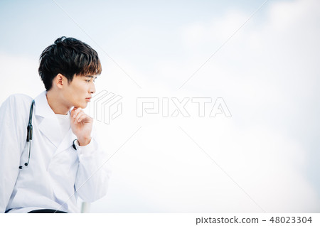 在站立在屋頂的白色外套的男性 48023304