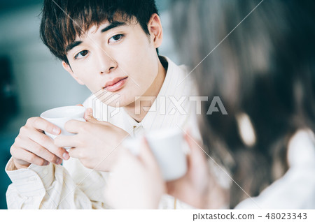 A man and a woman who talks with a mug in a rest room 48023343