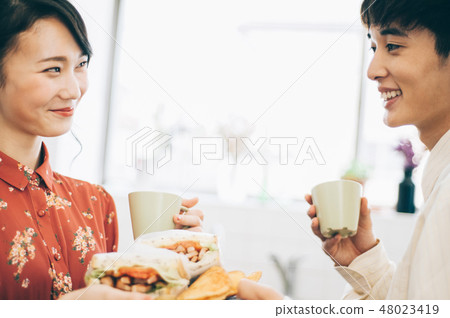 Men and women hand over sandwiches in the kitchen Men and women hand over sandwiches in the kitchen 48023419