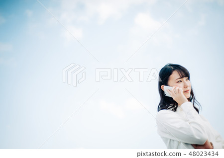 一件白襯衫的女人在屋頂上打電話 48023434